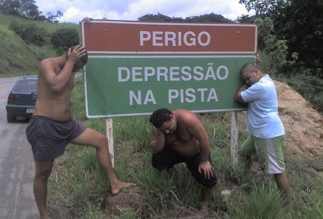 three guys acting depressed against a highway sign