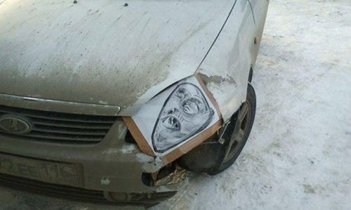 Broken down car has a headlight that's been printed on paper and framed.