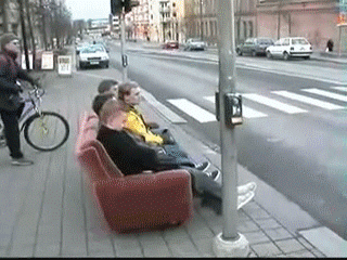 A pair of friends travel on a couch outside.