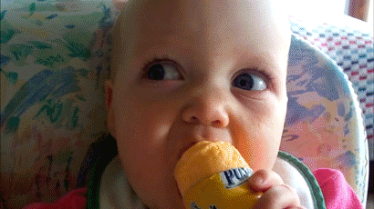 Baby eating food does a Gary Coleman impersonation with squinted eyes and an uptight mouth.