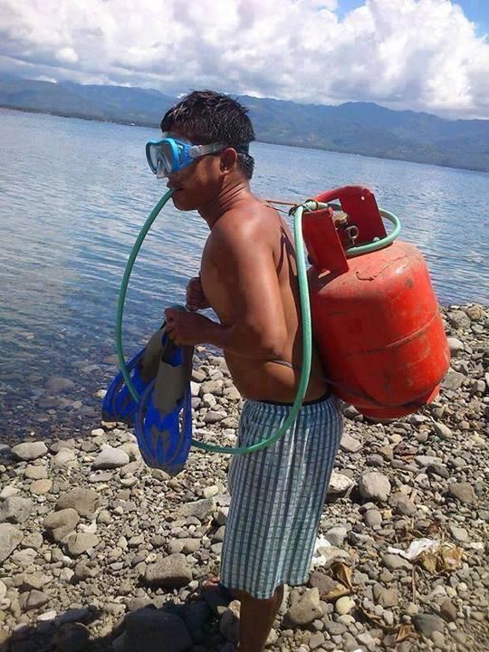 A man is geared with a propane tank and a hose is connected from his mouth to the tank.