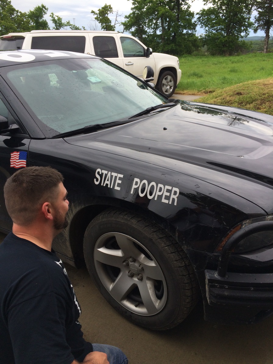 A cop's car says state pooper instead of state trooper after someone taped off the letter T and part of the R.